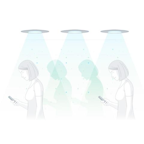 Women walking with cellphone below lights